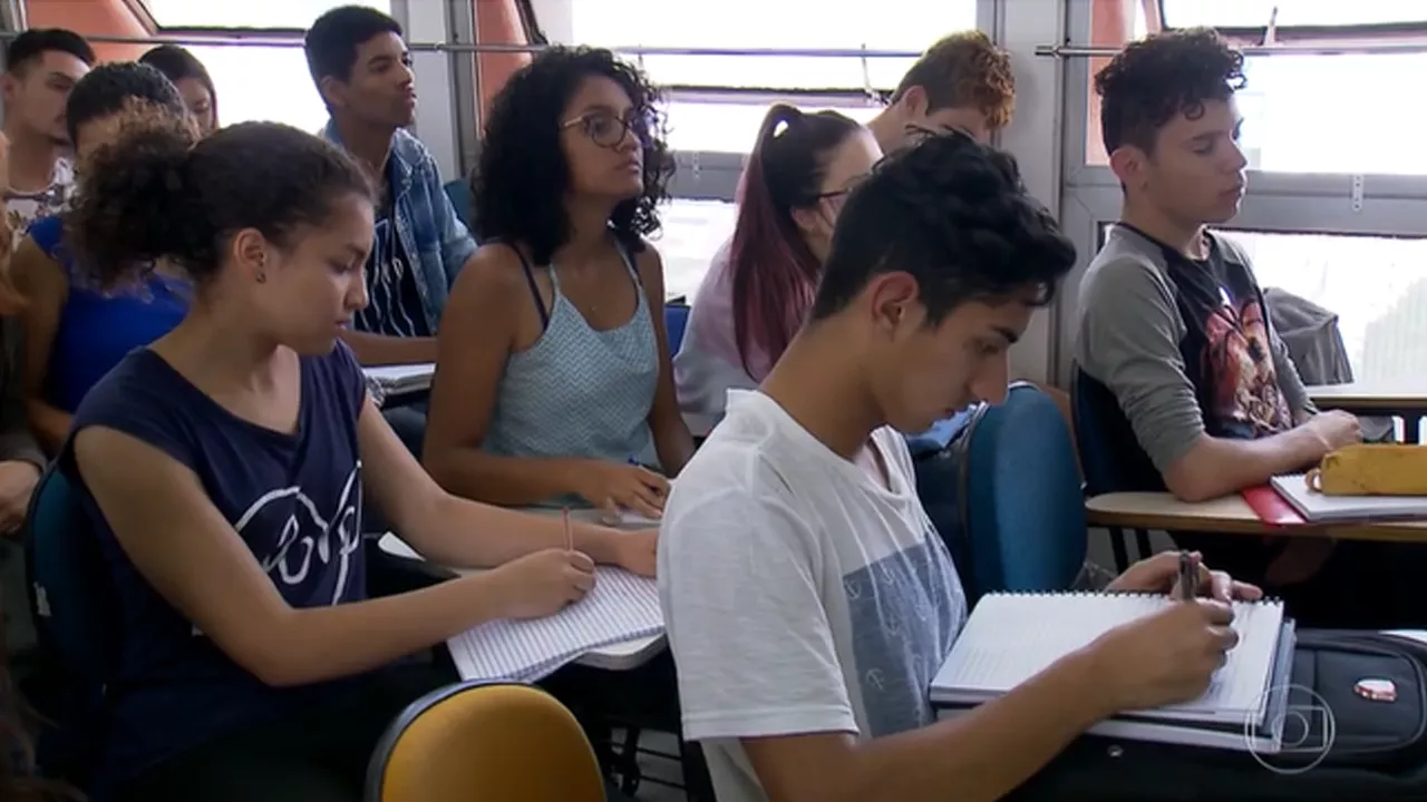 Alunos em sala de aula escrevendo em seus cadernos