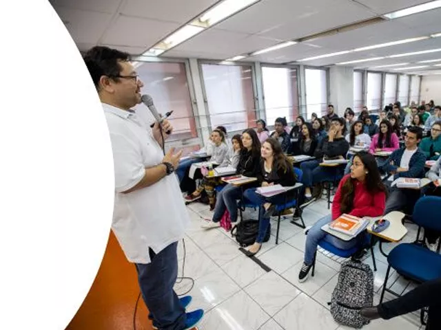 Professor ministrando aula para vários jovens em uma sala de aula